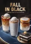 Three layered drinks and a slice of chocolate cake arranged on a dark table.