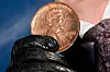 A person holds a giant penny at a mock funeral for the coin, which was discontinued earlier this year, Saturday, Dec. 20, 2025, in front of the Lincoln Memorial in Washington. (AP Photo/Julia Demaree Nikhinson)