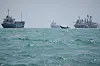 A motorboat travels past commercial vessels anchored in the Strait of Hormuz off Bandar Abbas, Iran, on Sept. 6.