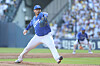 A Samsung Lions pitcher throws from the mound during a baseball game as a fielder stands in the background.
