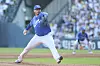 A Samsung Lions pitcher throws from the mound during a baseball game as a fielder stands in the background.