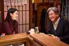 Han So-hee and Choi Min-sik converse across a wooden counter in a warmly lit Korean bar.