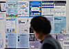 A person walks past a bulletin board displaying materials for recruitment support program at a college in Seoul on Aug. 18.