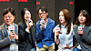 Five people hold microphones during a group interview.
