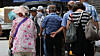 Older adults queue to receive a free meal near a public park in central Seoul on July 28.