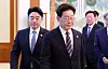 President Lee Jae Myung, right, enters a room for a meeting of senior presidential secretaries at the Blue House in central Seoul on Sept. 21, with presidential Chief of Staff Kang Hoon-sik seen on his left side.