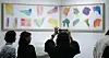 Visitors view colorful framed artworks at Frieze Seoul 2026, with one person taking a photo.
