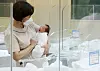 A nurse takes care of a newborn baby in a nursery in Yangcheon District, western Seoul, on Aug. 3.