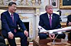 Xi Jinping and Donald Trump sit in the Oval Office with a model aircraft on a table between them.