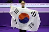 Yeo Seo-jeong holds a South Korean flag inside a purple gymnastics arena after winning gold.