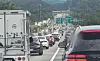 A long line of cars and trucks fills the Jungang Expressway near Wonju beneath Korean road signs.