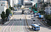A quiet Seoul boulevard with sparse traffic, city buildings, buses, and marked lanes.