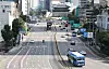 A quiet Seoul boulevard with sparse traffic, city buildings, buses, and marked lanes.