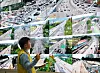 Worker viewing a wall of highway traffic monitors in a Korean traffic control center