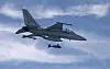 A South Korean FA-50 fighter jet releases a guided bomb against a cloudy blue sky.