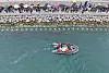 Officials use a boat and water pumps to guide the shark toward open waters at Busan North Port Waterfront Park in Busan, on Sept. 29.
