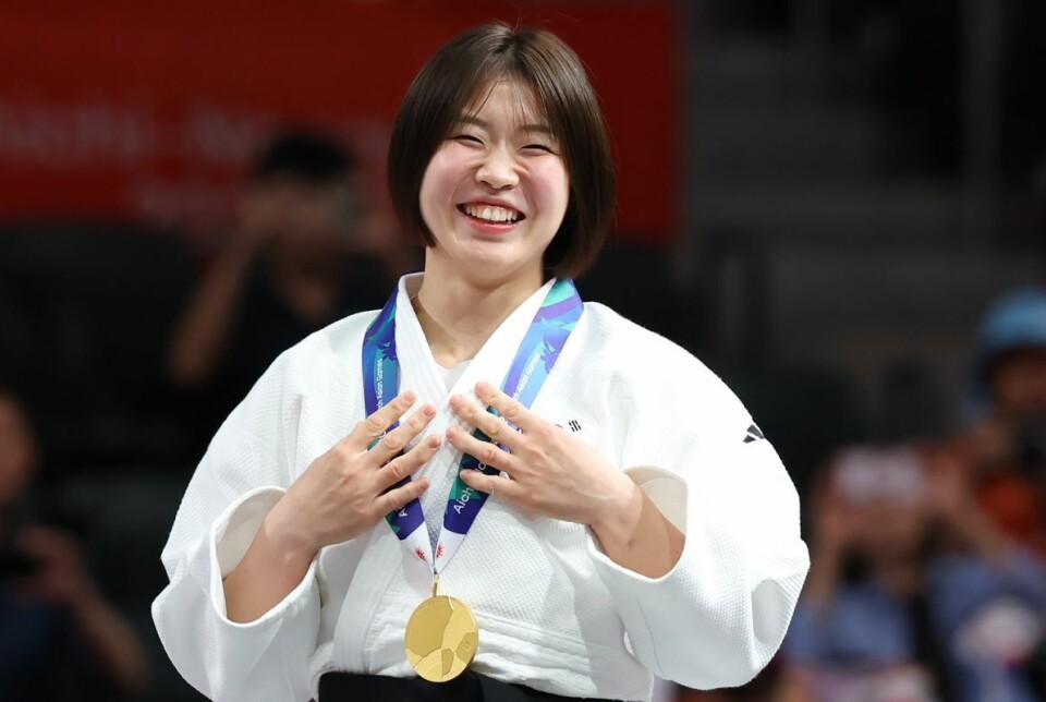 Huh Mi-mi smiles with her gold medal during the women’s 57-kilogram medal ceremony at the Aichi International Arena in Nagoya, Japan, on Oct. 1.