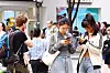 Tourists browse a crowded Myeongdong street in Seoul, with a woman checking her phone in the foreground.