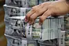 A hand holds a bundle of dollars at a bank in central Seoul on Sept. 3.