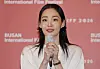 Kim Min-ha holds a microphone before a Busan International Film Festival backdrop.