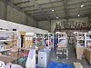 Warehouse aisles hold stacked boxes, shelving and blue pallets linked to a counterfeit cosmetics investigation in Cheongju.