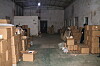 Cardboard boxes of counterfeit Korean cosmetics fill a dim warehouse in China during an IP Space raid.