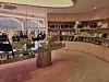 Interior of a luxury boutique with handbags, shoes and accessories on shelves and display tables.