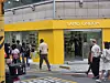 People walk past a yellow SAMO ONDOH storefront in an urban shopping district.