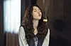 Chae Soo-bin as Na Bo-bae sits indoors with her eyes closed and long wavy hair.
