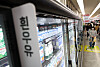 Refrigerated supermarket shelves display rows of milk products in Seoul.