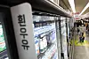 Refrigerated supermarket shelves display rows of milk products in Seoul.