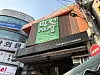 Street-level view of Mangwon Market's green sign and covered entrance in Seoul.