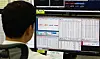 A dealer looks at a monitor displaying foreign exchange rates in the trading room at Hana Bank's headquarters in Jung District, central Seoul, on July 6, when Korea launched 24-hour foreign exchange trading.