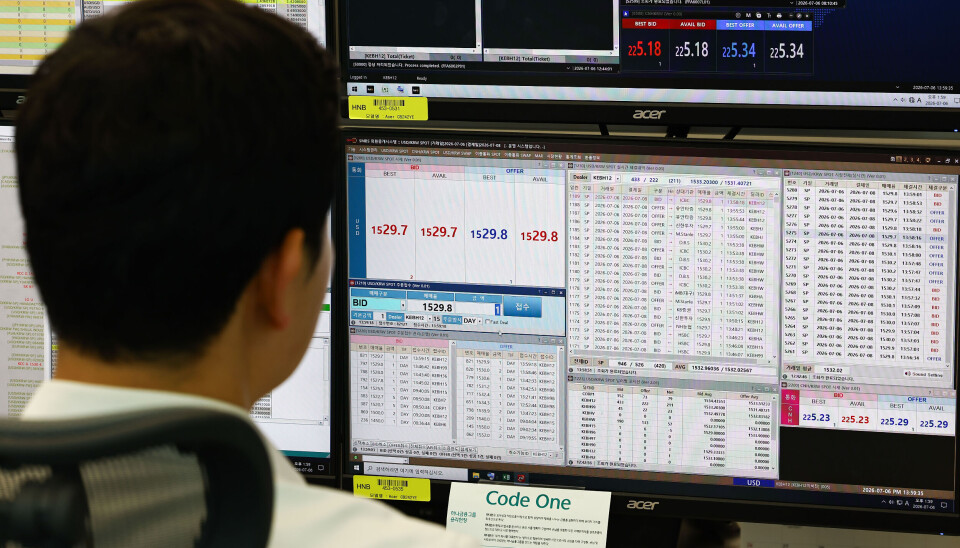 A dealer looks at a monitor displaying foreign exchange rates in the trading room at Hana Bank's headquarters in Jung District, central Seoul, on July 6, when Korea launched 24-hour foreign exchange trading.