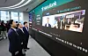 Then-Finance Minister Koo Yun-cheol, first from left, speaks via video call with employees at Hana Bank's London branch during a visit to the dealing room at the bank's headquarters in Jung District, central Seoul, on July 6, the first day of 24-hour foreign exchange trading in Korea.