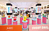 Colorful character figures displayed on pink pedestals at a department-store character goods event.