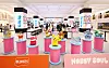 Colorful character figures displayed on pink pedestals at a department-store character goods event.