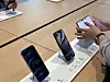 Customer tests an iPhone Duo beside other smartphones on an Apple Hongdae display table.