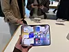 Customer holds an unfolded iPhone Duo above a display table at Apple Hongdae in Seoul.