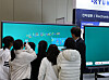 Students gather around an AI electronic board demonstration at a metal industry exhibition.