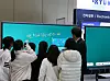 Students gather around an AI electronic board demonstration at a metal industry exhibition.