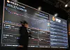 A person walks in front of a screen displaying Bitcoin prices in southern Seoul on Feb. 9.